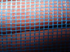 A hand is holding a piece of blue interweave insect screen.