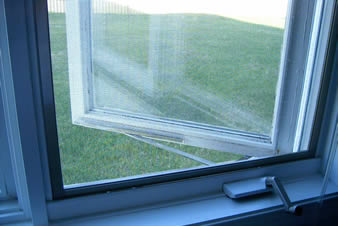 The white plain weave insect screen is installed on the window of the house and the glass window is half-open.