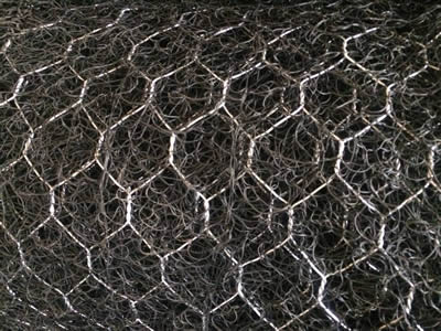 A roll of 3D geomats are attached with galvanized hexagonal wire mesh.