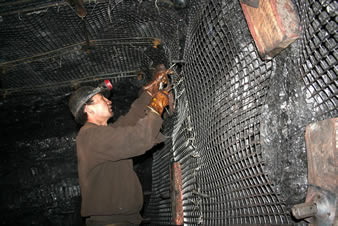 A worker is fixing the biaxial plastic geogrid on the mine tunnel.