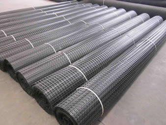 Eleven rolls of biaxial plastic geogrid on the ground.