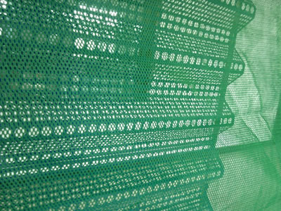 A piece of green flexible windbreak netting is attached onto the steel windbreak netting.