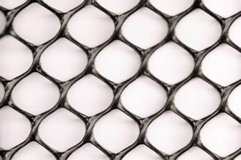 A piece of dark hexagonal grass protection mesh on the white background.