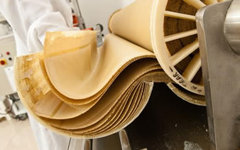 A worker is operating the machine to produce the reverse osmosis filter.