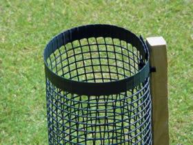 A piece of green square mesh tree guard is fixed on a wooden post.
